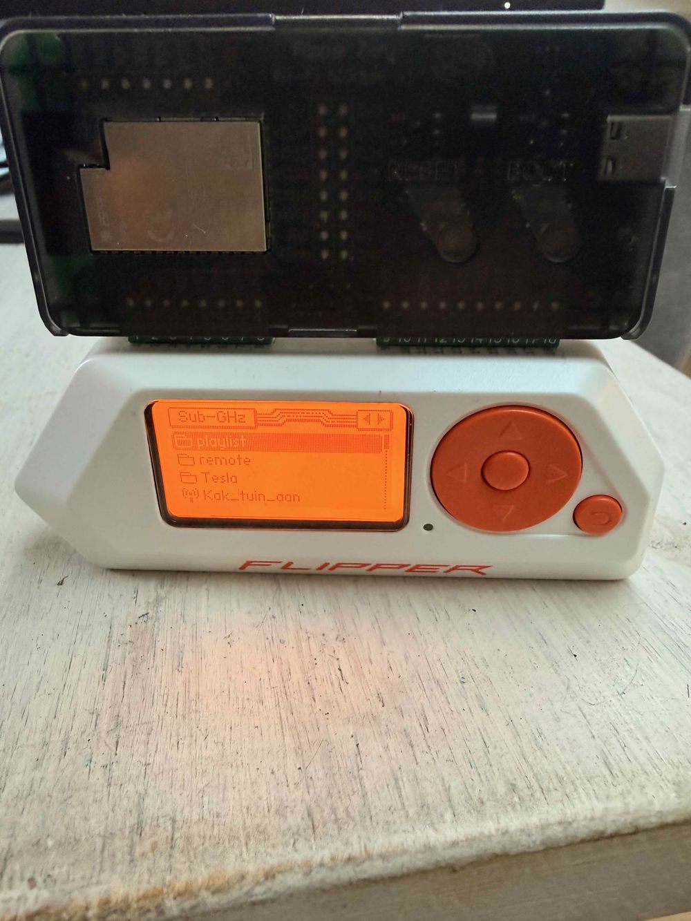 Flipper Zero met een ESP32-bord op de GPIO-pinnen en het Sub-GHz-menu op het scherm